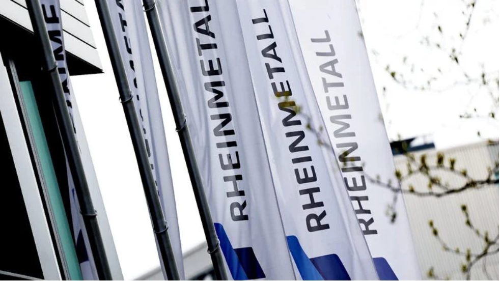 Weiße Fahnen mit der Aufschrift "RHEINMETALL" wehen im Wind.