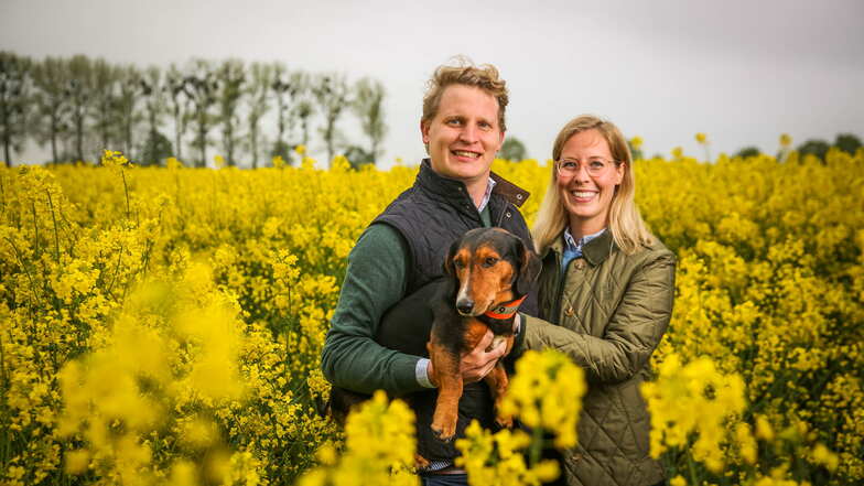 Bild zeigt Ehepaar Grundherr in einer Rapswiese mit Hund.