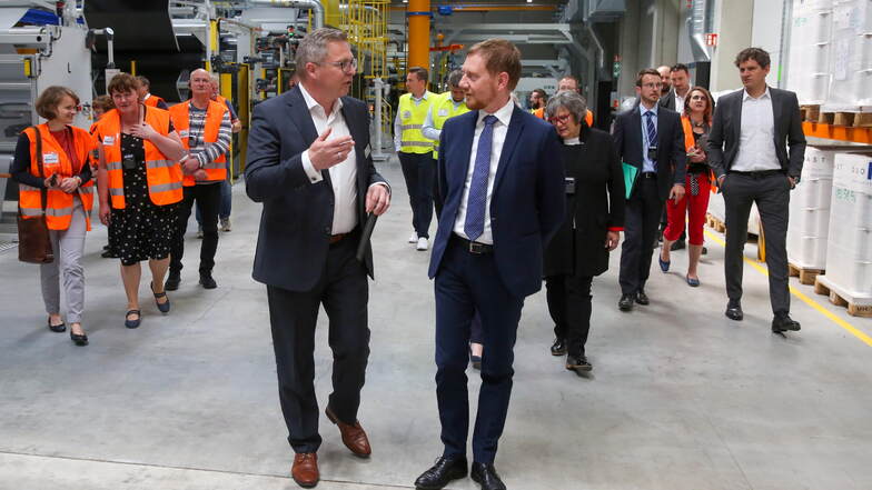 Michael Kretzschmar und Werksleiter der Firma Bauder in Schwepnitz Andreas Pohontsch laufen nebeneinander.