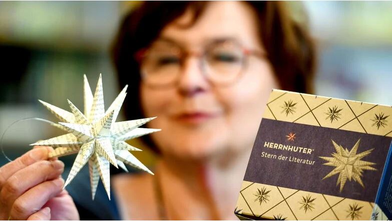 Heike Csoti von der Herrnhuter Comenius-Buchhandlung mit dem neuen Herrnhuter, dem "Stern der Literatur" zum 125. Jubiläum der Buchhandlung.