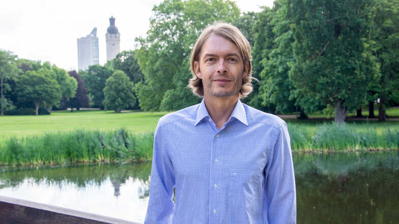 Iven Kurz, in einem blauen Hemd vor einem See der Stadt Leipzig, hat es sich zur Aufgabe gemacht, die Finanzwelt nachhaltig zu gestalten.