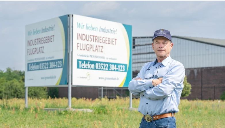 Das Bild zeit einen Mann vor dem Schild des Industriegebiet Flugplatz.