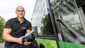 Das Bild zeit einen Mann vor einem Bus.