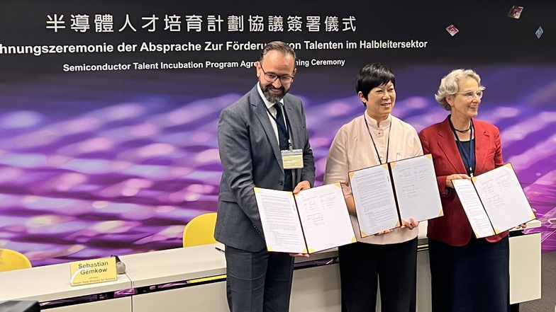 Sachsens Wissenschaftsminister Sebastian Gemkow, Lora Ho, Senior-Vize-Präsidentin von TSMC und Professorin Ursula Staudinger, Rektorin der Technischen Universität Dresden, unterschreiben eine Kooperationsvereinbarung.