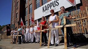 Man sieht Mitarbeiter:innen protestieren.