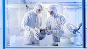 Mitarbeiter vom Leipziger Unternehmen Intelligent Fluids heben einen Wafer aus einer Transportbox.