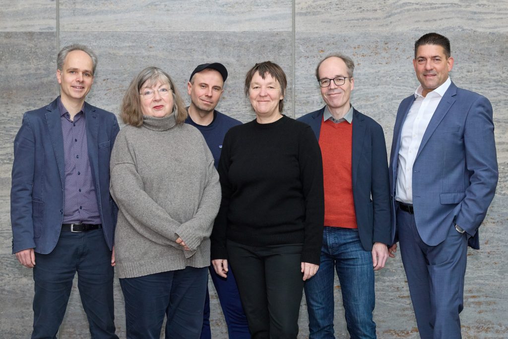Eine Gruppe von Menschen schaut in die Kamera.