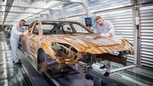 Man sieht Porsche-Mitarbeiter bei der Qualitätskontrolle des Fahrzeugs.