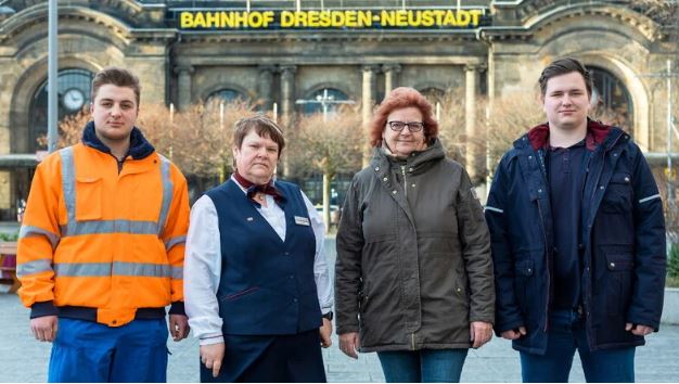 Man sieht vier Mitarbeitende der Bahn.