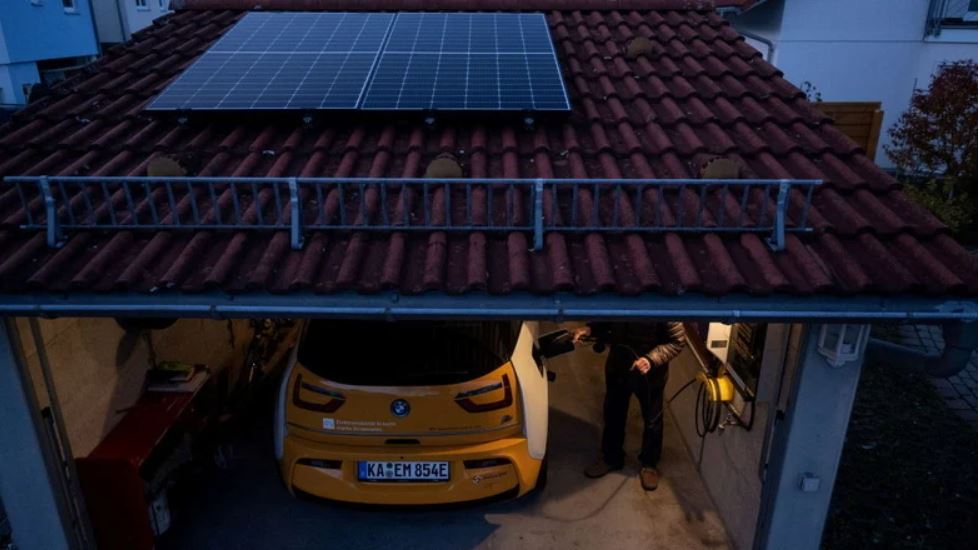 Man sieht eine Solarmodule auf dem Dach und eine Wallbox in der Garage für das Elektroauto