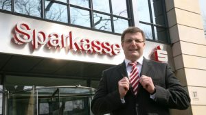 Man sieht Ostsachsens Sparkassenchef Joachim Hoof vor der Sparkasse