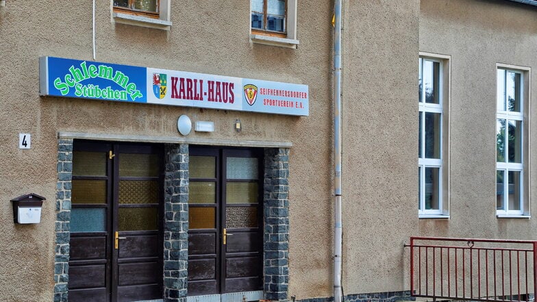 Man sieht ein altes Haus mit Reklame.
