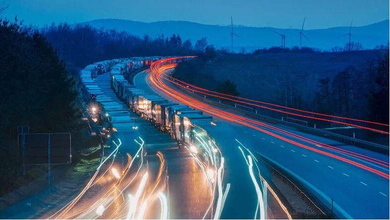 Man sieht eine volle Autobahn bei Dunkelheit.