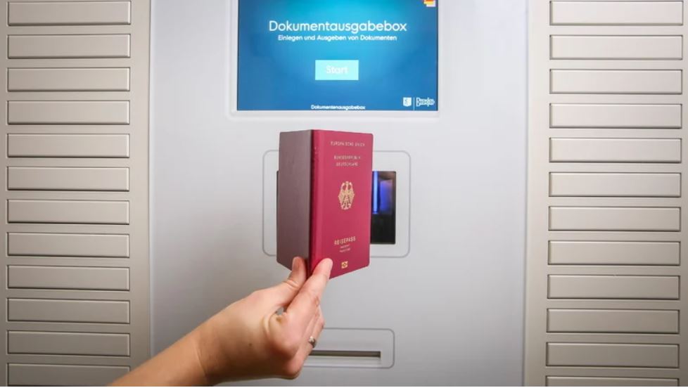 Man hält einen Passport vor einer elektronischen Dokumentenausgabebox zum Einscannen