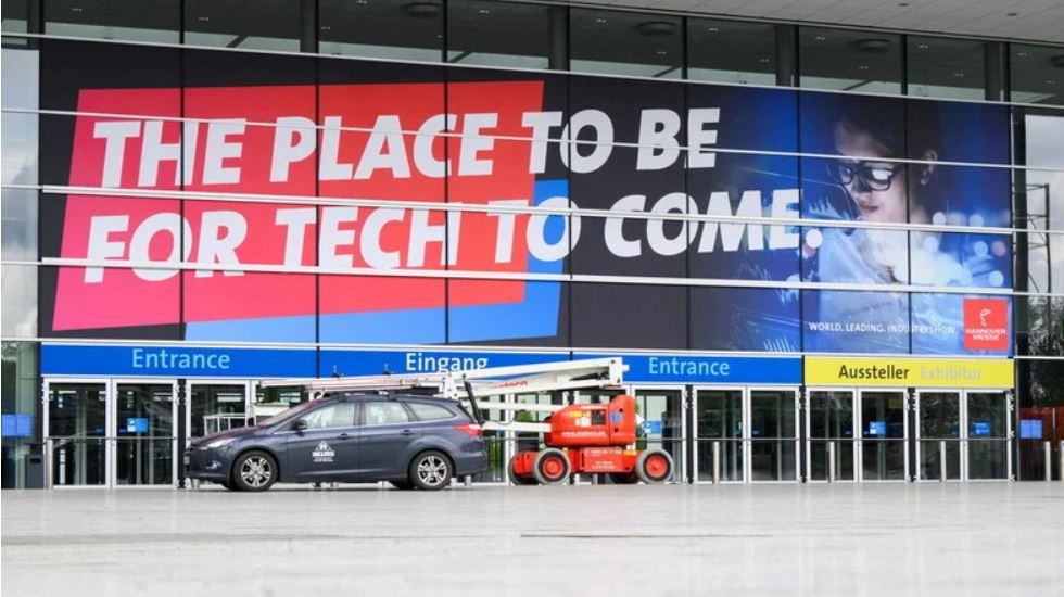 Man sieht die Hannover Messer mit einem großen Plakat "The place to be for Tech to come"
