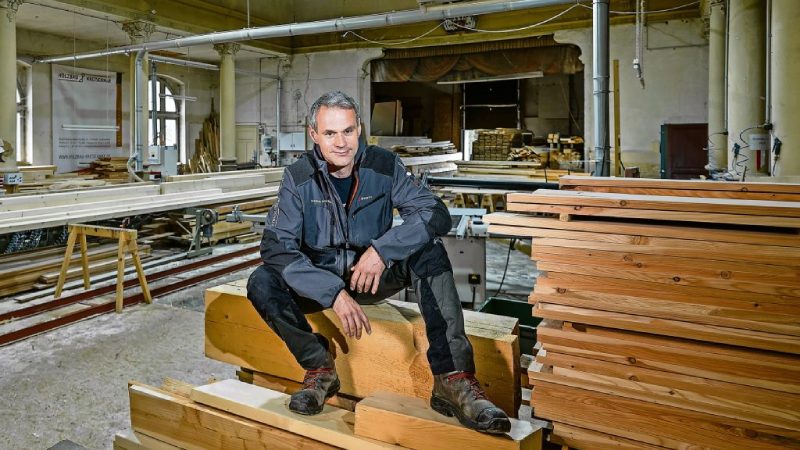 Ein Mann sitzt in einer Holzwerkstatt.