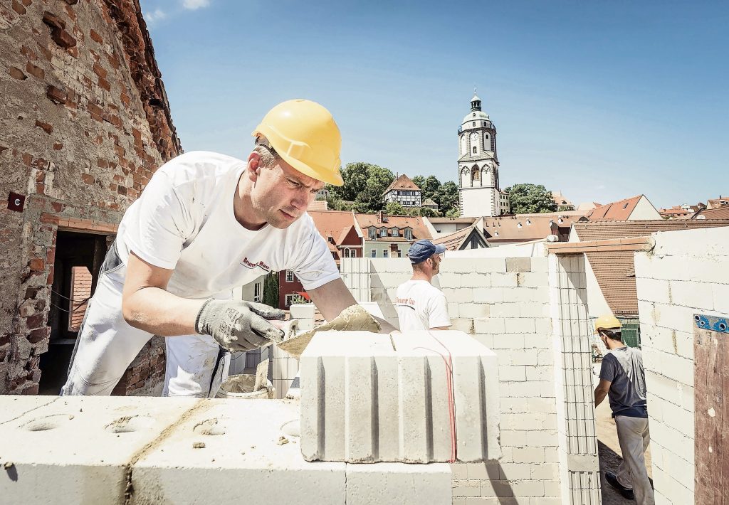 Der Minister Martin Dulig packt auf einer Baustelle mit an.