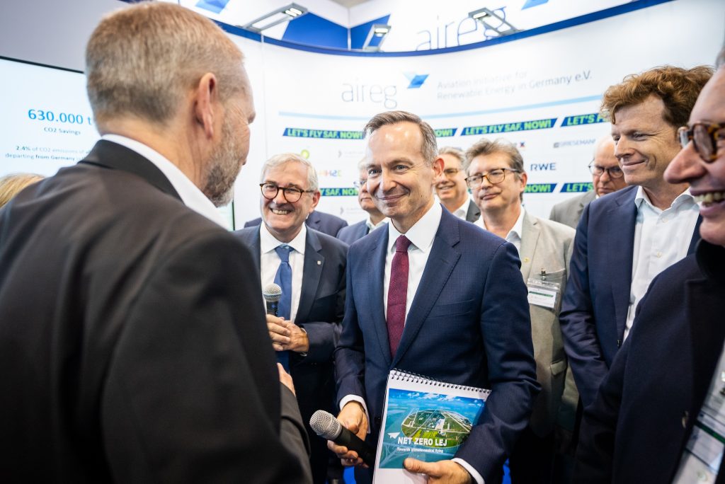 Ein Mann im Anzug bekommt ein Dokument überreicht.