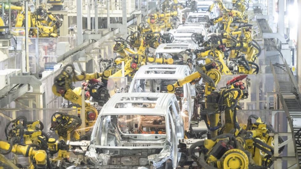 Man sieht die Produktion von Elektroautos mit sehr vielen Industrierobotern.