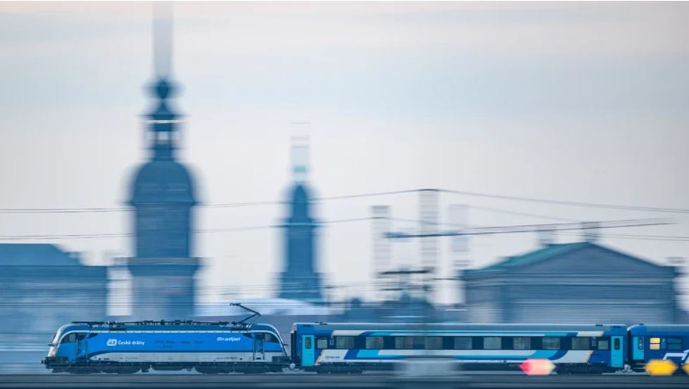 Man sieht einen Eurocity Zug, der gerade über die Brücke fährt.
