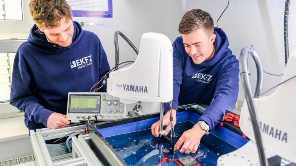 Man sieht Tönnis Trittler und Julian Kober im Labor von HybridEcho, die gerade das Ultraschallgerät testen