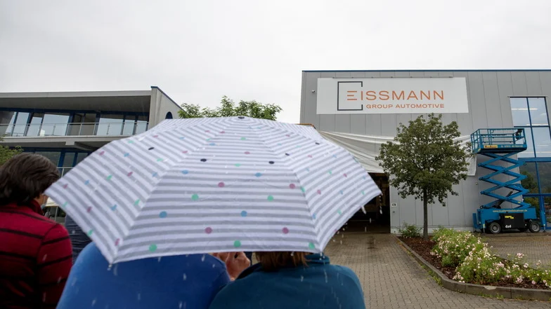 Man sieht Personen unter einem Regenschirm.