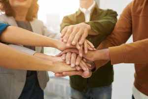 Mehrere Menschen legen die Hände übereinander.