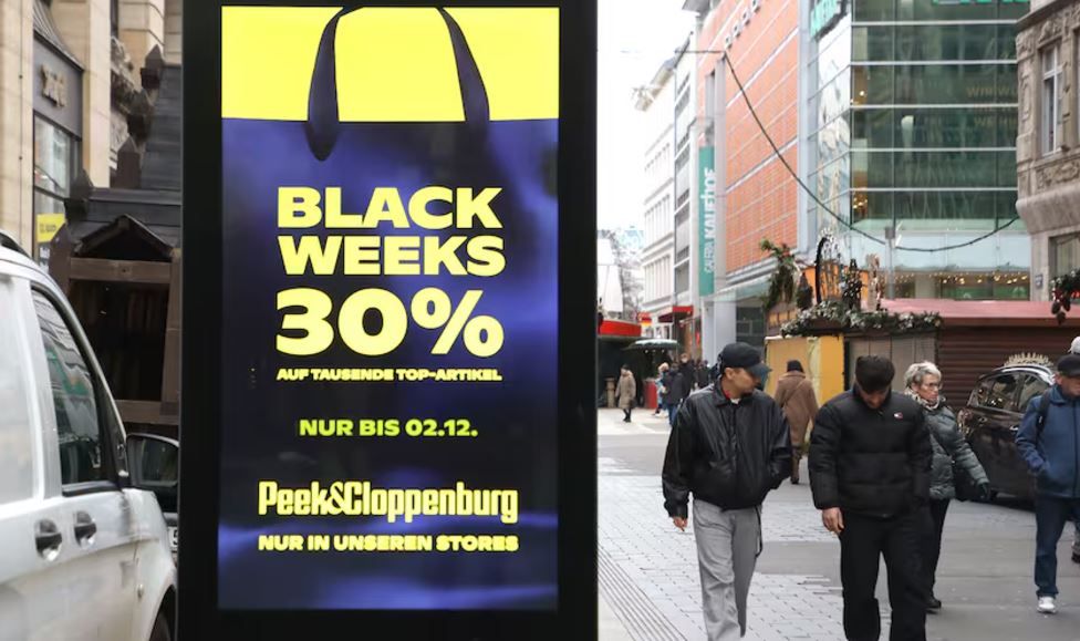 Man sieht Menschen in der Altstadt und eine Werbung für Black Week von Peek&Cloppenburg