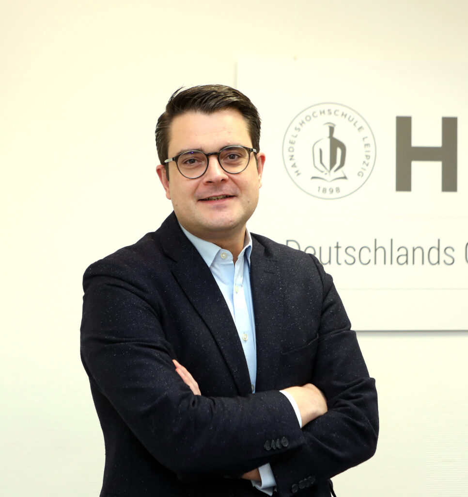 Ein Mann schau lächelnd in die Kamera.