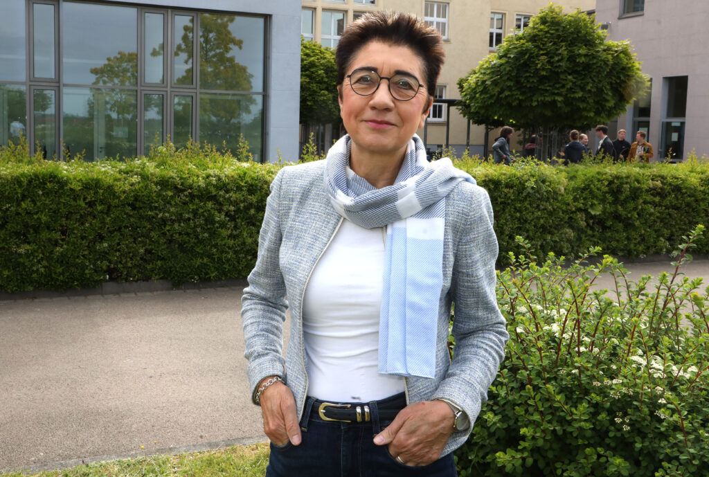 Eine Frau schaut freundlich in die Kamera.