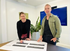 Zwei Menschen schauen freundlich in die Kamera.