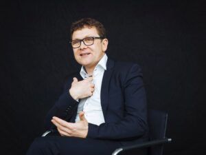 Ein Mann schaut freundlich in die Kamera.