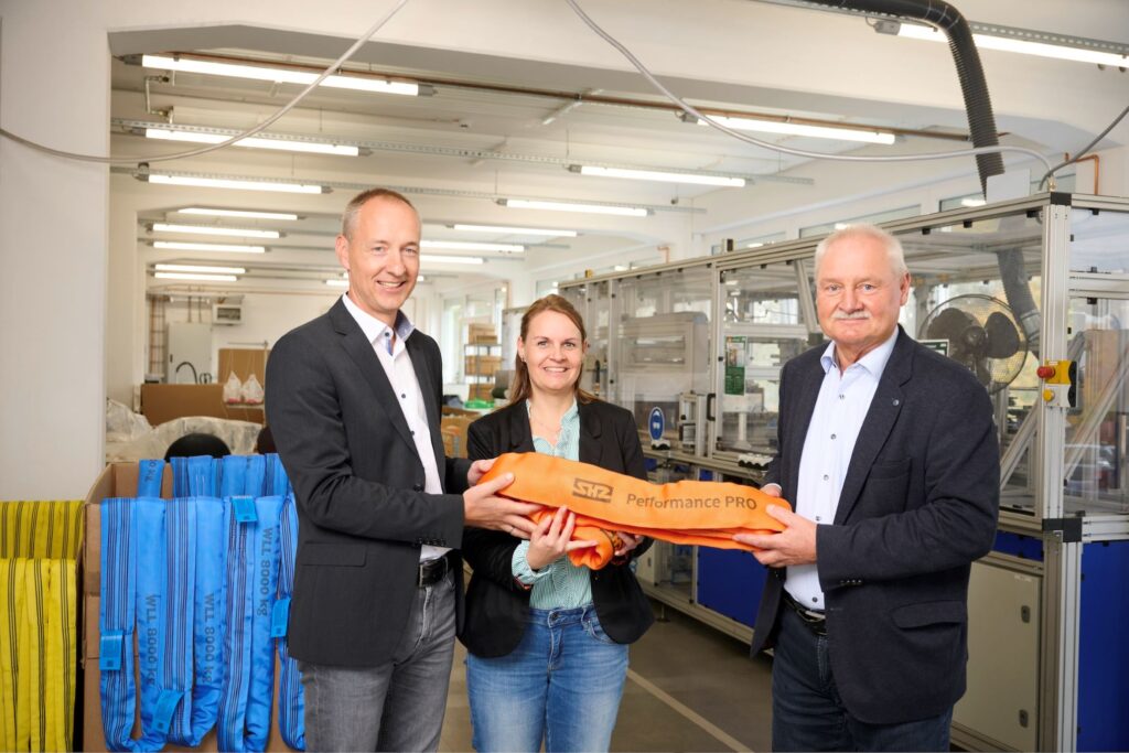 Zwei Männer und eine Frau schauen freundlich in die Kamera.