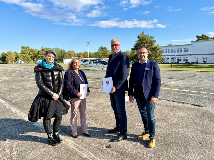 Vier Menschen schauen freundlich in die Kamera