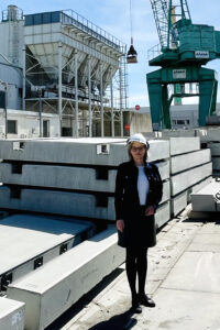 Eine Frau steht auf einem Betriebsgelände.