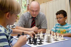 Ein Mann und zwei Kinder spielen Schach.