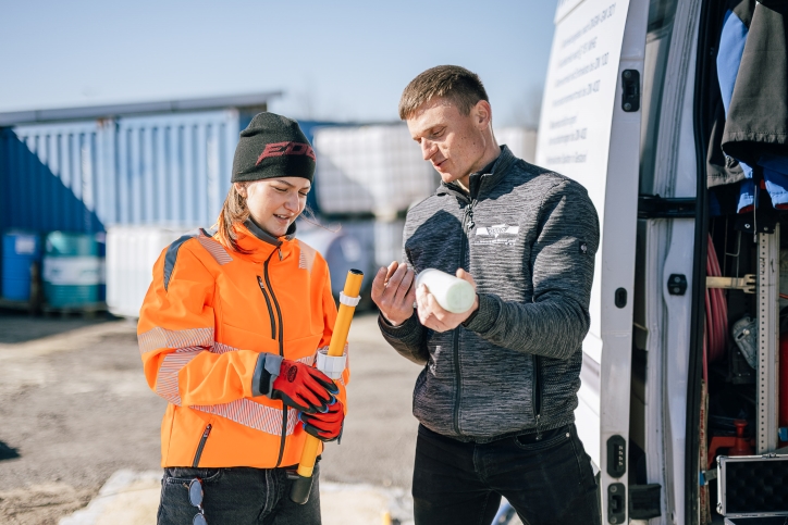 Zwei junge Leute stehen auf einer Baustelle.