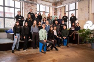 Eine Gruppe Menschen schaut freundlich in die Kamera.