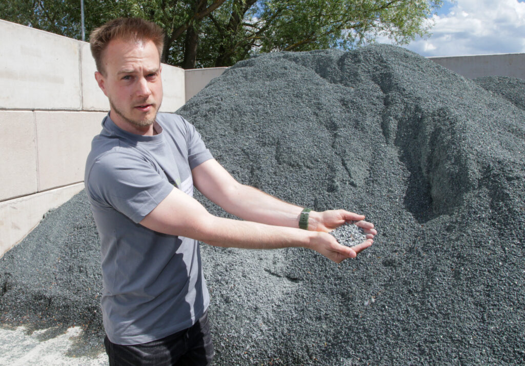 Ein Mann zeigt ein Mineraliengemisch.