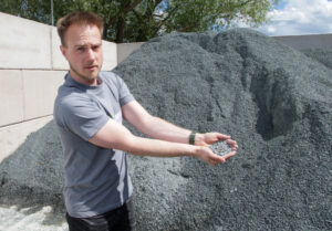 Ein Mann zeigt ein Mineraliengemisch.