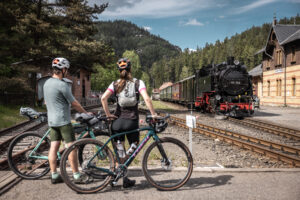 Zwei Radfahrer stehen an einem Bahnhof