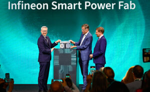 Drei M&auml;nner stehen unter dem Schriftzug Infineon Smart Power Fab