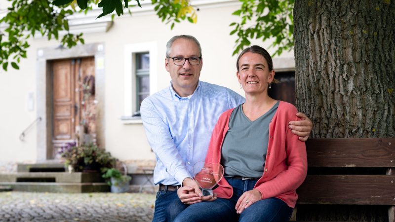 Ein Mann und eine Frau sitzen unter einem Baum.