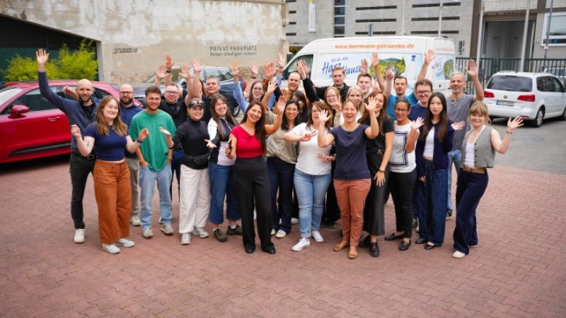 Eine Gruppe Menschen schaut erfreut in die Kamera.